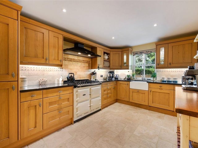 The kitchen is fitted with an extensive range of storage with integrated appliances and an Aga range cooker.