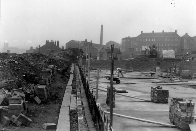 The construction of a static water supply basin built as a wartime measure on the grounds and site of Tiplin Hall off Savile Drive, which had been demolished in the early 1930s. Cement skimming is in progress. In the background are industrial buildings on Buslingthorpe Lane, a mill chimney and Bronte House on Scott Hall Road. Pictured in August 1942.
