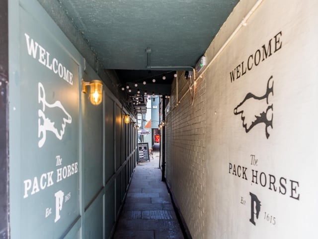A pub on the site of The Pack Horse first opened in 1615 as The Nag's Head although they may have been watering hole on the site since the 1130s. In 1780 it changed its name to the Slip Inn. In 1982 it was renovated following 15th century elements of the original and became The Pack Horse we know today. The Templar Cross can be seen at the front of the pub. This shows it was originally owned by the Order of St John of Jerusalem, sucessors to the Knights Templar.
