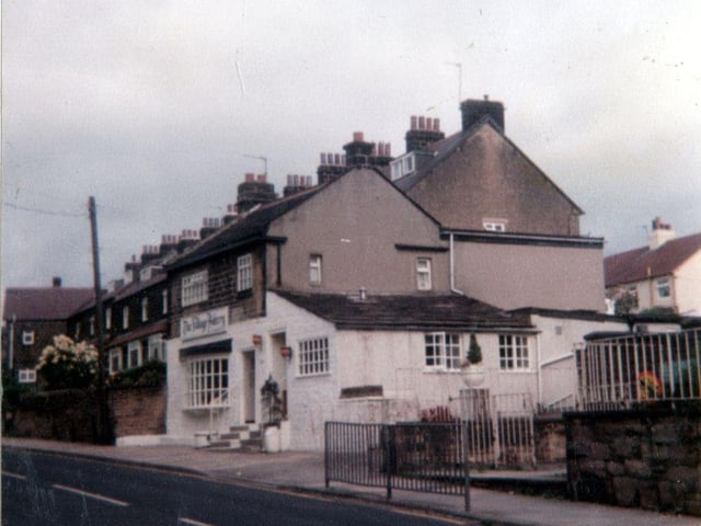 The white painted building in the centre is the Village Bakery in Rawdon. On the right is entrance to St. Peter's Junior and Infant School.