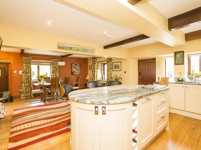 The kitchen has fitted units and granite worktops, with a work island and breakfast bar. Integrated appliances include a fridge freezer, dishwasher, double oven and induction hob.