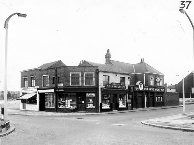 The junction of Domestic Street and Wortley Lane in  March 1965. On the left is Frank Young, butcher on Domestic Street followed to the right by L. Roberts, drapers. Continuing right is a Clarkson Ltd on Wortley Lane, this is a chemists. The St George's Inn is on the right.