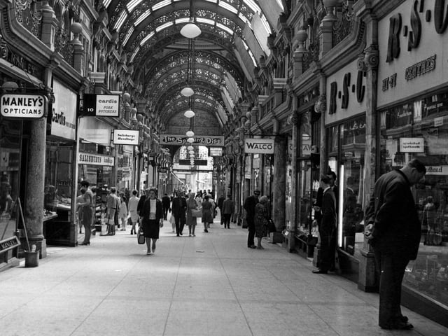 A view looking down the County Arcade from the Briggate end to Vicar Lane in Shops include Manley's opticians, Cardis Pork butchers, Salisbury's handbags, Walco, RSC Hi Fi centres and Instant shoe repairers. A sign for the Spinning Disc disco is also visible.