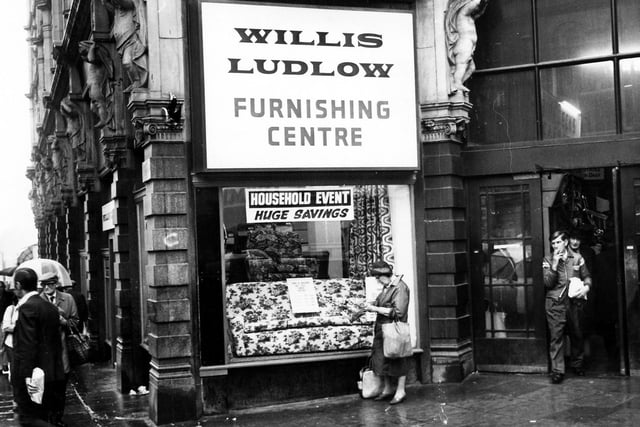The shop window of the Willis Ludlow department store, displaying sofas and chairs and advertising 'huge savings' in January 1979.