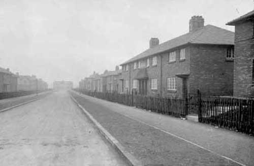Rows of terraced and semi-detached houses on the Miles Hill Estate. The view is possibly Miles Hill View and the road is sloping downwards to meet what is possibly Miles Hill Road. Pictured in February 1930.