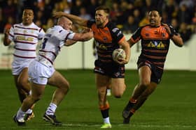 Castleford's Greg Eden fends off Trinity's Lee Kershaw. Picture by Jonathan Gawthorpe.