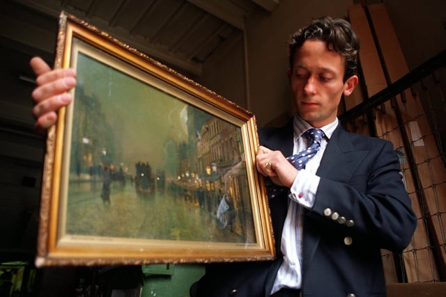 Assistant picture specialist Andre Zlattinger displays Briggate, Leeds, by painter John Atkinson Grimshaw at Phillips auctioneers  in Leeds.