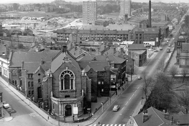 Armley Methodist Church is in the foreground with Branch Road to the left and Stanningley Road to the right. The Western Cinema is on the left edge; further back are the Eyres, the Beeches, the roofs of the Palace Cinema and Skating Rink, the flats of Burnsall Gardens and Burnsall Court and Winker Green Mill with the chimney. In the background are Theaker Lane, Armley Moor and West Leeds High School on the skyline. On the right edge are the playground of Armley Park School, the trees and wall of Armley Liberal Club and the woolshop at the bottom of Armley Lodge Road.