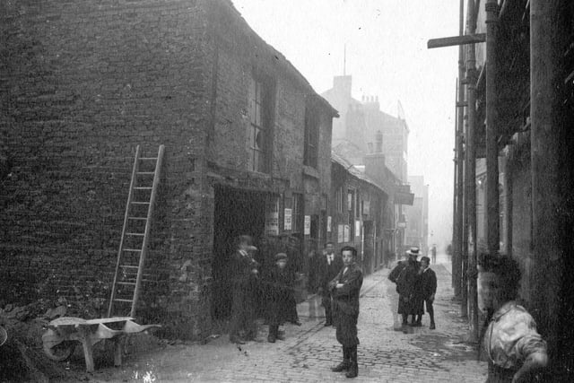 Lands Lane improvements in September 1898. To left, wheelbarrow and ladder, children in period dress looking at camera. Lands Lane took its name from fields or lands belonging to the Lord of the Manor of Leeds.