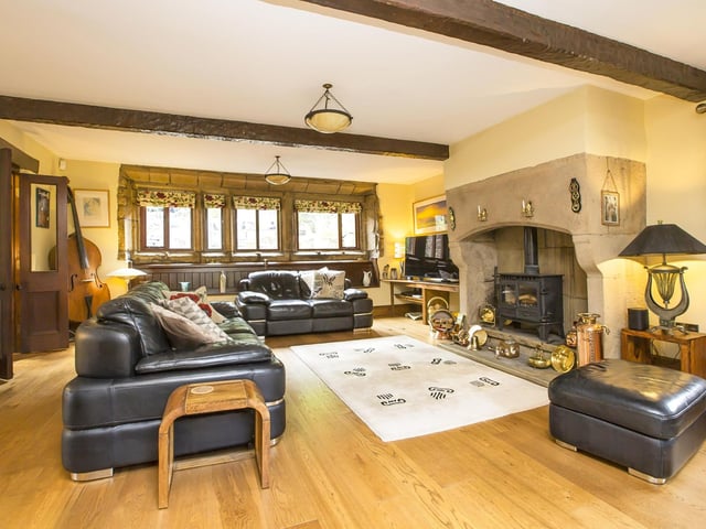 A huge Inglenook fireplace is a centrepiece  in the spacious lounge with exposed stone walls.