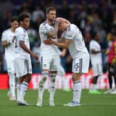 'HEART-BREAKING': Defeat for Leeds United against Arsenal on Sunday as Whites captain Liam Cooper consoles Rasmus Kristensen and Tyler Adams, left, looks on. 
Photo by Eddie Keogh/Getty Images.