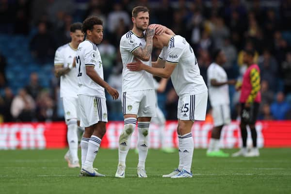 'HEART-BREAKING': Defeat for Leeds United against Arsenal on Sunday as Whites captain Liam Cooper consoles Rasmus Kristensen and Tyler Adams, left, looks on. 
Photo by Eddie Keogh/Getty Images.