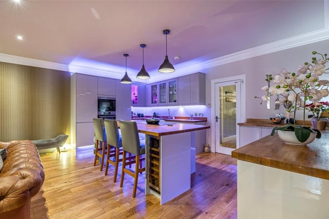 The open-plan kitchen has lots of storage, a central island and wine fridge.
