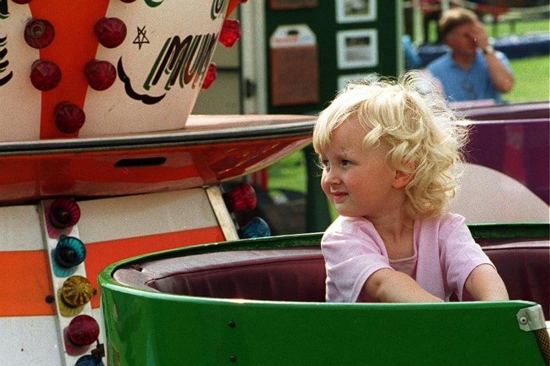 Anyone for tea? A young  girl sits and waits for her turn in a giant tea cup at Leeds Show.