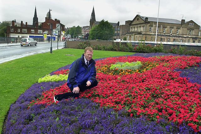 Richard Gill, who is in charge of floral displays in the city centre, is pictured next to one on Woodhouse Lane,  near The Dry Dock pub.