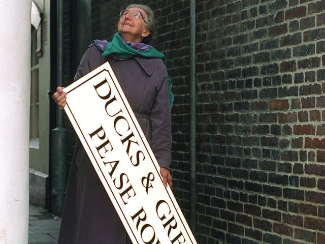 Local historian Nina Jones decides where the sign for the newly named ginnel Ducks & Green Pease Row should be placed in Pontefract town centre in December 1997.