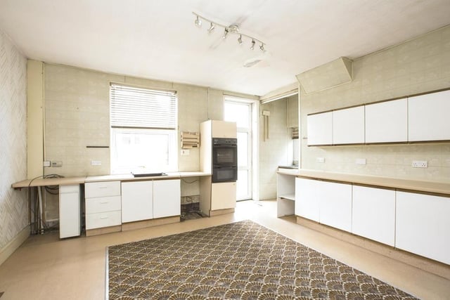 The kitchen has a spread of units with space for appliances.