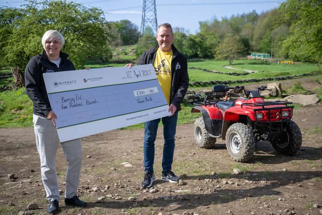 Nicola of David Wilson Homes presenting the cheque to Chris at Bumpy Ltd