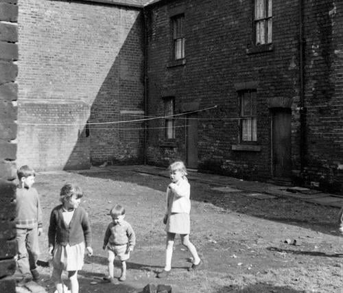 Children play on an unmade road on Back Barker Square in April 1969.