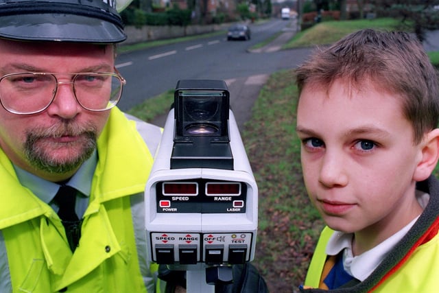 Pupils from St Joseph School in Tadcaster helped North Yorkshire Police in January 1999 by using a speed camera and stopping motorists to inform them of the dangers of speeding and the change of speed limit along Station Road in the town. Pictured is traffic management officer Dave Brown and pupil Jamie Cusworth.