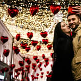 A couple poses for a selfie under heart-shaped balloons displayed for Valentine's Day in downtown Moscow on February 13, 2020. (Photo by Dimitar DILKOFF / AFP) (Photo by DIMITAR DILKOFF/AFP via Getty Images)