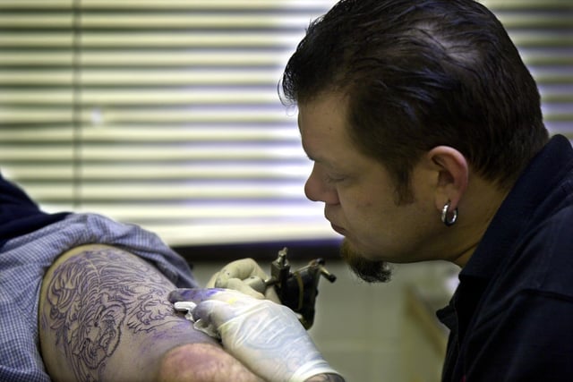 Dewsbury tattooist Dave Banfield during his attempt to set a record for the longest non-stop tattoo session in January 2002. He is pictured working on Paul Spiers.