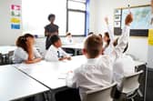 Students raising their hands in class.