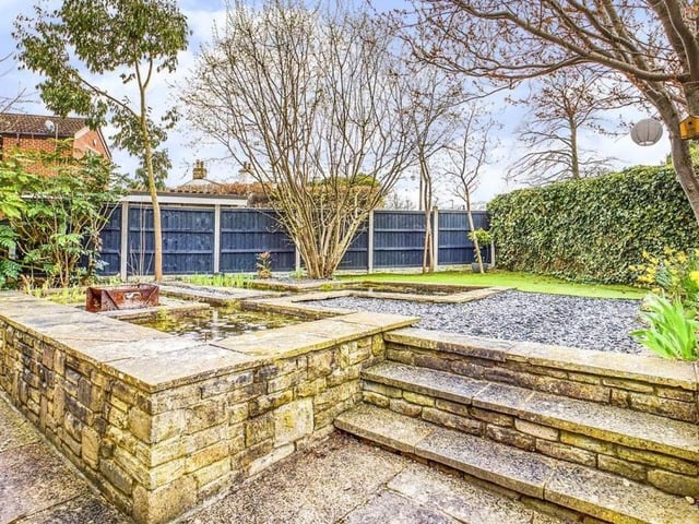 A garden pond is a feature of the garden to the front of the house.
