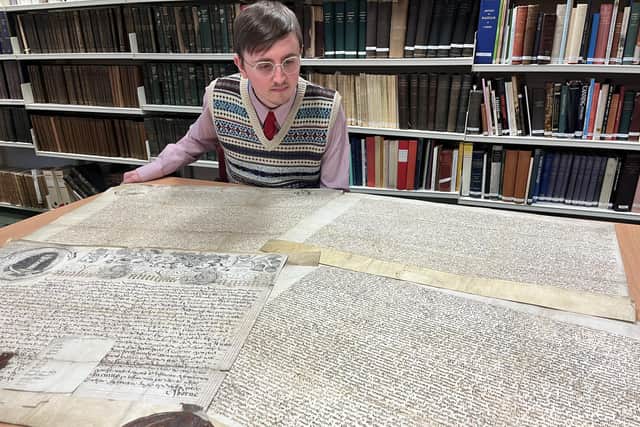 Archive assistant Alex Pearson with the Leeds Charter and a charter granted by Charles II which laid the foundations of modern-day Leeds