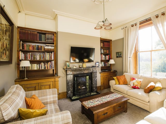 The original marble fireplace is a focal point in this lounge.