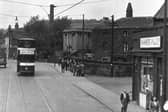 A tram travels along Meanwood Road  in JUn e 1955 with F W White, Drysalters, visible on the right. Next to this, covered in ivy and at an angle to the road, is Bog Hall. This house was adjacent to the ancient sulphur spa well and was possibly named for the bog land which typically produced sulphur springs. The spire of St Michael's Church on Buslingthorpe Lane can be seen above the roof. The light coloured building after Bog Hall is the transformer building for the trams on Meanwood Road, while the chimney to the left of this is in the Carr Mills complex on Buslingthorpe Lane. These buildings have all since been demolished leaving the white building on the far left as the only building in the image still standing. This is the Primrose pub at the junction of Meanwood Road and Buslingthorpe Lane.