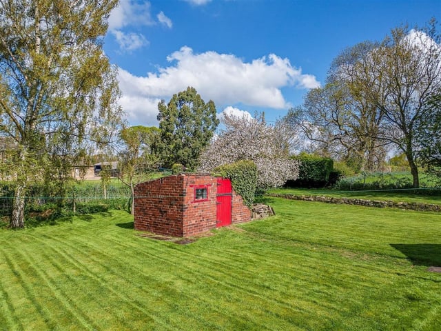To the rear is an attractive lawned garden with brick built toilet with a timber door, a brick built outbuilding and a concrete driveway.