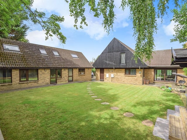 The property has wrap-around garden areas with seating.