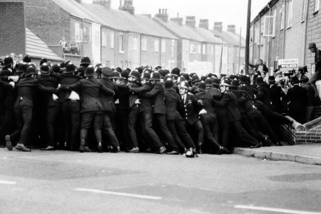 A line of police contains pickets on a side street opposite Allerton Bywater Colliery in August 1984.