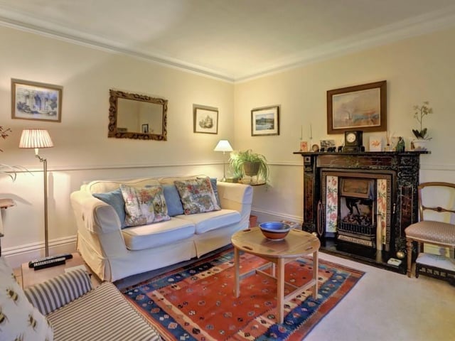 The original cast iron fireplace lends an element of cosy warmth to the sitting room.