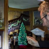 Trust property curator Simon McCormack dressing the dolls' house for Christmas