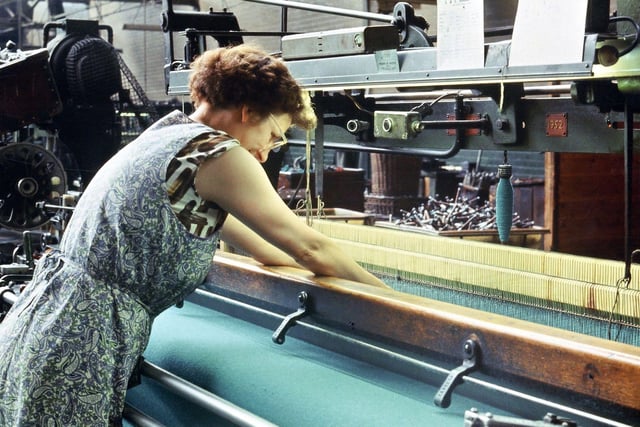 Dorothy Ladley mends a broken thread on a Northrop loom in the large weaving shed.