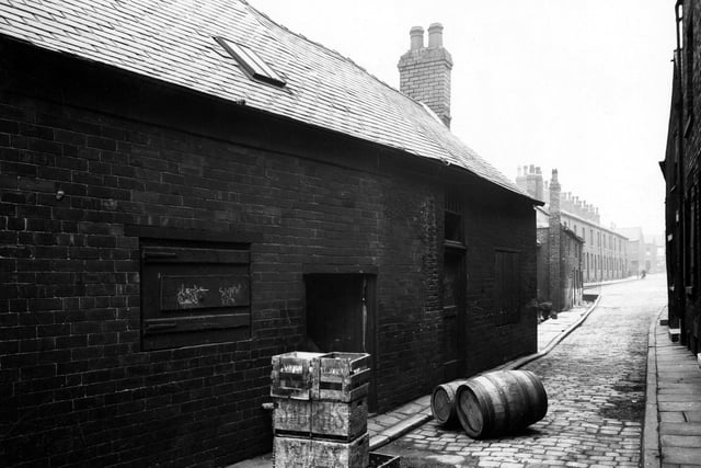 The premises on Carr Fold off Balm Road in July 1946. Crates containing bottles and two barrels lie on the cobbled street, these are for the off license on Balm Road. At the end of the terraced houses is the junction with Telford Terrace.