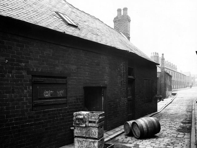 The premises on Carr Fold off Balm Road in July 1946. Crates containing bottles and two barrels lie on the cobbled street, these are for the off license on Balm Road. At the end of the terraced houses is the junction with Telford Terrace.