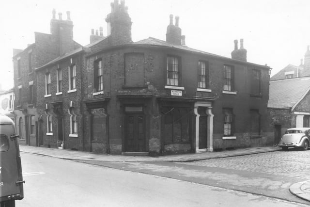 At the left edge is a shop facing onto Meanwood Road at number 62, John Jones greengrocer. Moving right is Barrack Street, number 9 is at a corner with Wilmington Terrace. This former furniture shop is boarded up, on the right is 1 Wilmington Terrace then yard area behind Meanwood Road shops. Pictured in October 1960.