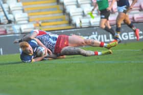 Luis Roberts beats Zak Hardaker to touch down for Rhinos at Leigh. Picture by Steve Riding.