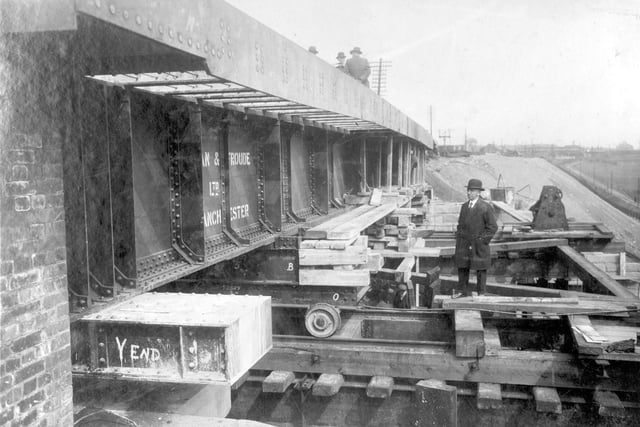Construction of a railway bridge across the Ring Road in April 1931. Bridge section is being manoeuvred into position. Work is being watched by man in bowler hat.