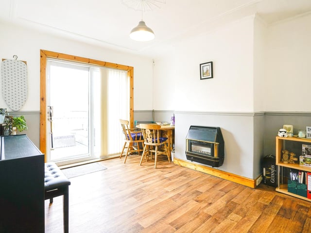 Downstairs, a bright and airy lounge has a feature fireplace and window to the front, and the dining room has sliding french doors leading to the rear garden with a wall mounted gas fire.