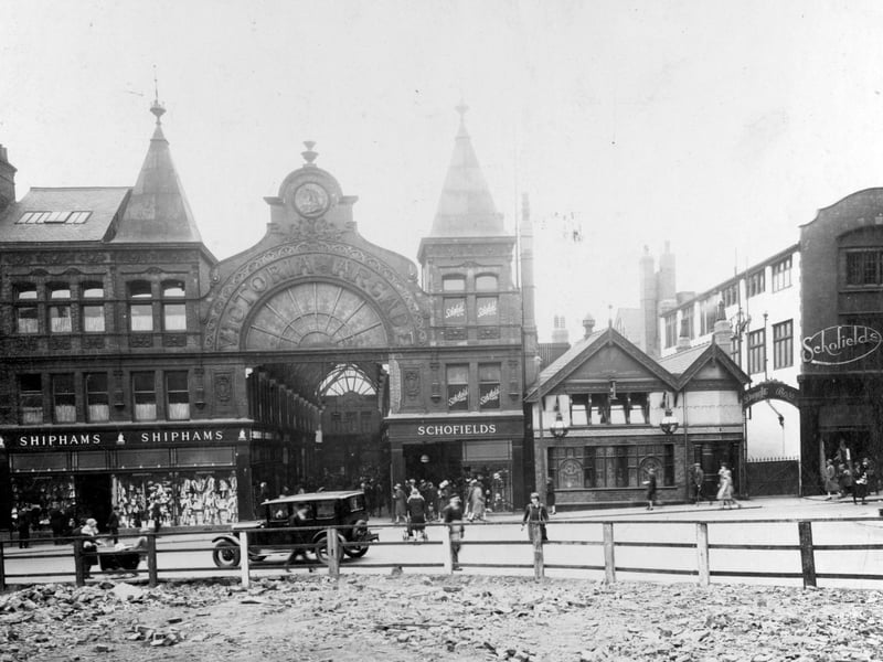 A photograph of June 1930 which shows Schofields on either side of the Cock and Bottle, but before the store took over the whole of Victoria Arcade. The L-shaped arcade was designed in 1898 by Thomas Ambler and named to celebrate Queen Victoria's Diamond Jubilee; it connected Upperhead Row with Lands Lane. The glazed roofs of the two arms of the arcade met in a glass dome, and the archway in Upperhead Row, decorated in faience, was topped with an image of Queen Victoria.