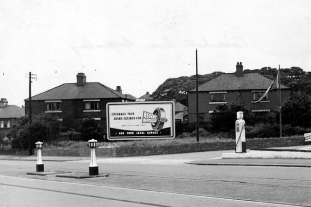 A large advertisement for Regent Remoulds tyres in front of Green Hill Place in July 1953. Tram tracks and bollards are visible in the foreground and a petrol pump can be seen on the right.