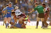 Corey Johnson, left, watches on as Leeds Rhinos' Sam Lisone is tackled by Liam Horne of Castleford Tigers' Liam Horne. Picture by John Clifton/SWpix.com.