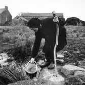 Farmer Hannah Hauxwell is pictured drawing her water for domestic use at her farm in Baldersdale.