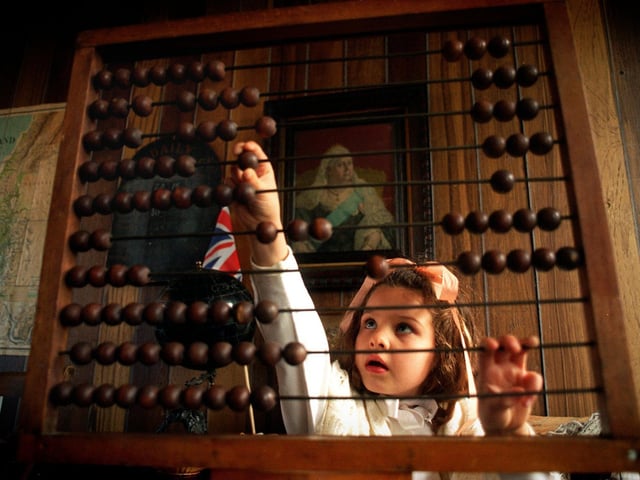 Adding-up the Victorian way in December 1996. Young Emily Dolphin  went back in time when she dressed in Victorian clothes to attend lessons in the reconstructed Victorian classroom at Armley Mills Museum, Leeds. Emily visited the museum with a party  of schoolchildren from Upper Wortley Primary School to take part in a Victorian study.