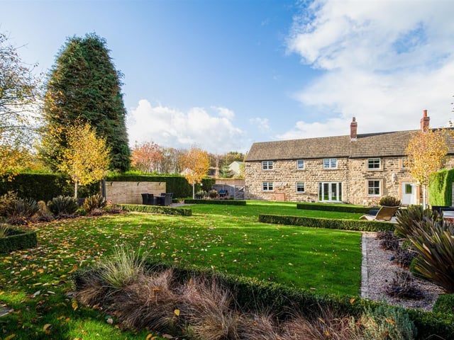 The lawned garden is divided in to zones, with patio seating areas for the warmer months.