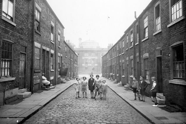 Children, one with a bicycle, pose in the centre of Imperial Street. Joseph Hobsons Dantzic Brewery has been built on the site of East Imperial Street. Two storey brick houses with cellars, in state of dilapidation.